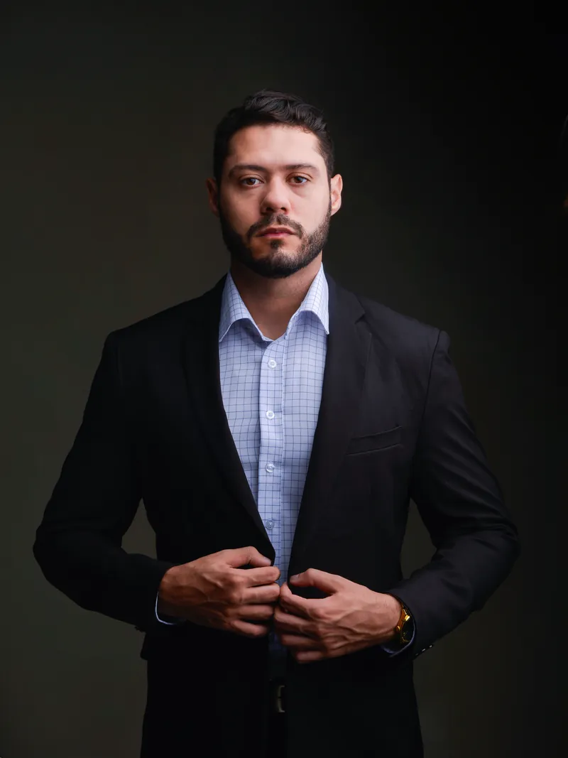 Yuri Henrique Oliveira da Rosa, advogado, em retrato de meio-corpo, de pé, de terno escuro e camisa clara.